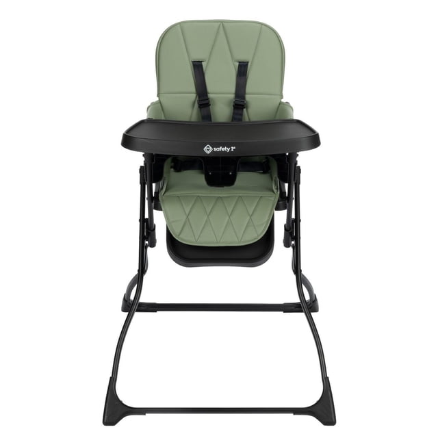 Safety 1st Compact Lily High Chair front view with sage green padded seat featuring diamond stitching, black adjustable harness, and black detachable tray on a black metal frame designed for compact folding and easy cleaning, ideal for baby feeding.