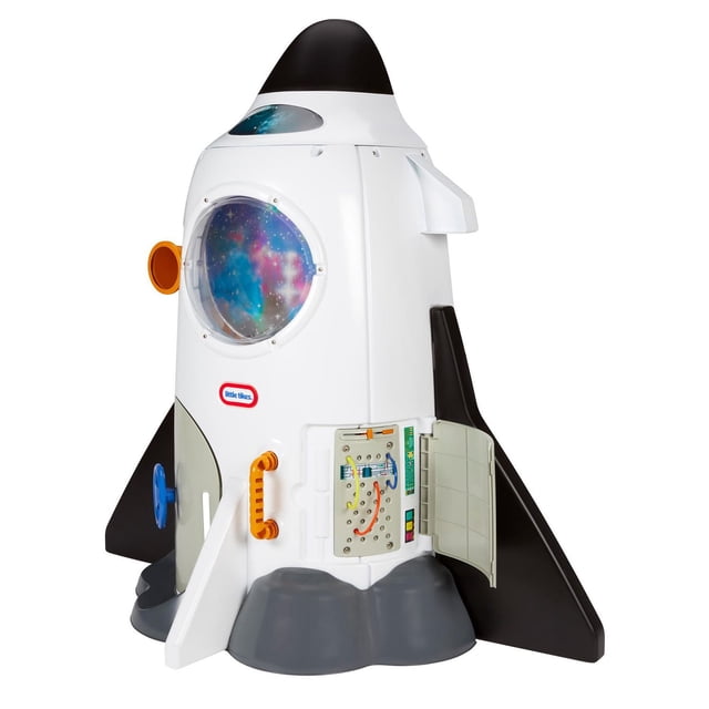 Little Tikes Adventure Rocket playhouse in a 3/4 profile view showing a white plastic rocket ship with black fins and nose cone, a large round window with a starry galaxy decal, an open maintenance panel with colorful wires, and orange and blue handles for interactive outdoor play.