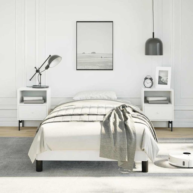 vidaXL Cadre de Lit Blanc 100x190 cm Simple en Similicuir Exposé dans un Cadre de Chambre Moderne. le Cadre de Lit Présente une Finition Élégante en Similicuir Blanc, Soutenu par des Pieds Noirs Robustes pour la Stabilité. le Cadre Est Conçu pour s'Adapter à un Matelas Simple 100x190 cm (Non Inclus) et Comprend des Lattes en Contreplaqué pour une distribution Uniforme du Poids. la Chambre Est Stylée avec des Tables de Nuit Blanches Assorties, un Tapis Gris et un Décor Minimaliste, Créant une Atmosphère Propre et Invitante.