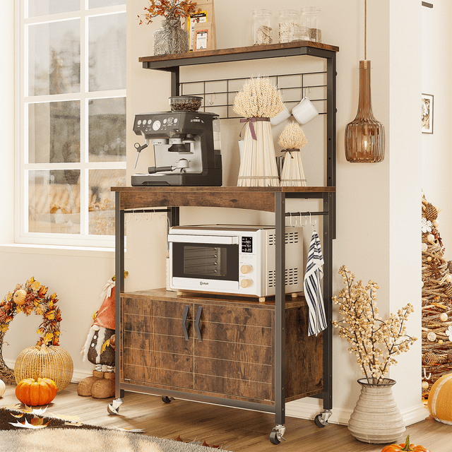 Bestier 3-Tier Kitchen Baker's Rack Microwave Oven Stand with Cabinet designed for kitchen storage and organization. Features a sturdy steel frame, P2 particle board shelves, three open tiers, a spacious cabinet, and 10 S-hooks for hanging cups or towels. Shown in a warm kitchen setting with a coffee machine, microwave, and decorative items. Includes lockable wheels for mobility and adjustable feet for stability, making it versatile for various spaces.