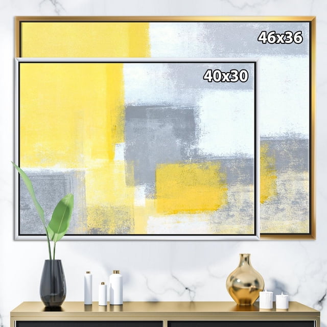 Designart Grey and Yellow Blue Abstract XXI FLOAT FRAME WALL ART featuring two framed canvas prints with abstract yellow, grey, and blue blocks in a modern style, displayed above a gold console table with decorative vases and candles, suitable for enhancing contemporary home décor.