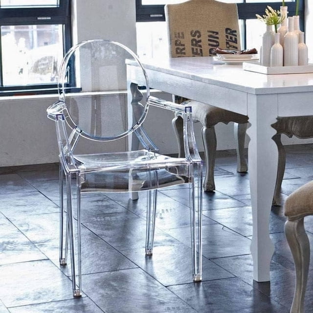 Heavenly Collection Plastic Arm Chair featuring clear polycarbonate construction with King Louis round back design, placed in a dining room with dark tile flooring and white dining table, blending modern minimalist and classic styles for kitchen and dining seating.