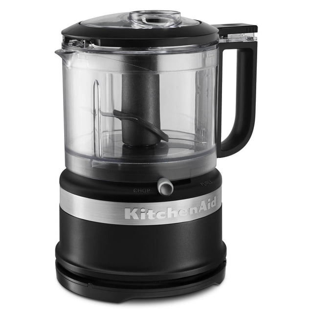 KitchenAid® 3.5 Cup Food Chopper with a transparent 3.5 cup work bowl, black handle, and pour spout on a matte black base with a silver KitchenAid logo band, featuring a locking stainless steel blade and a lid with a drizzle basin for easy sauce and dressing preparation, ideal for chopping, mixing, and pureeing fresh ingredients.
