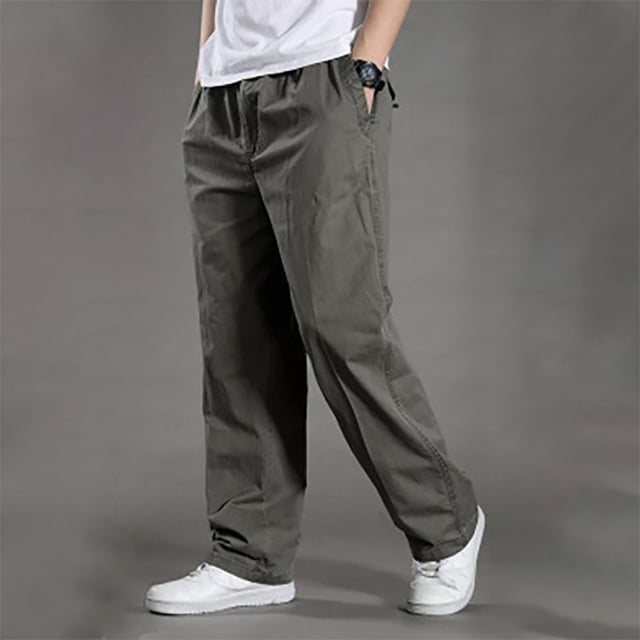 EGNMCR Pantalon Léger pour Homme, Pantalon cargo Droit Uni Ajusté Conçu pour les sports et Loisirs Décontractés en Plein Air. Fabriqué en Coton Respirant, Ce Pantalon Pleine Longueur Présente une Taille Élastique avec Cordon pour le Confort. Présenté dans un Ton Neutre, Assorti à des Espadrilles Blanches, sur un Fond Gris Uni.