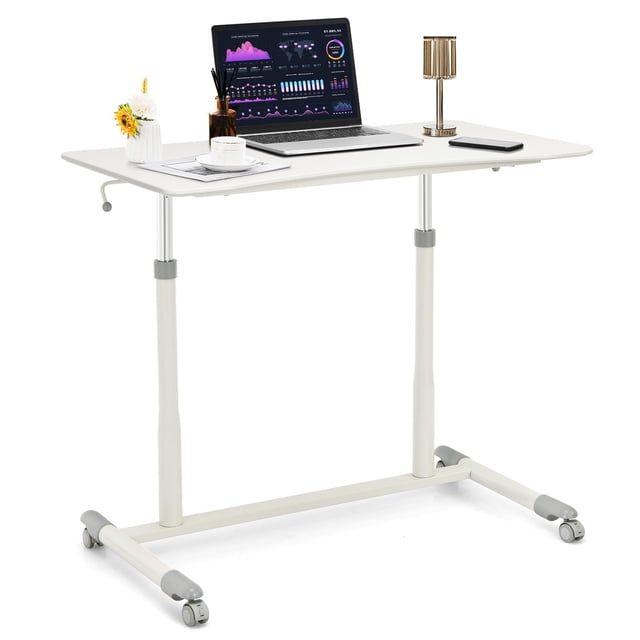 Giantex Mobile Height Adjustable Standing Desk in white, designed for ergonomic use with a spacious desktop featuring rounded corners and a curved edge. The desk includes a pneumatic gas-lifting system for smooth height adjustment from 27.5 to 42 inches, supported by sturdy steel legs and a durable MDF surface. Equipped with four casters, two lockable, for easy mobility and stability. Suitable as an ergonomic rolling laptop table for home office use, shown with a laptop, lamp, and decor items on the surface.