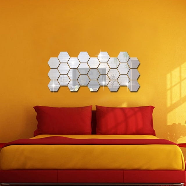 Meitianfacai 36Pcs Mirror Hexagon Vinyl Removable Wall Sticker Decal Home Decor Art displayed on a vibrant yellow wall above a bed with red and yellow bedding. The hexagonal acrylic stickers create a reflective, mirror-like effect, arranged in a grid pattern. Suitable for decorating living rooms, bedrooms, or dining areas.