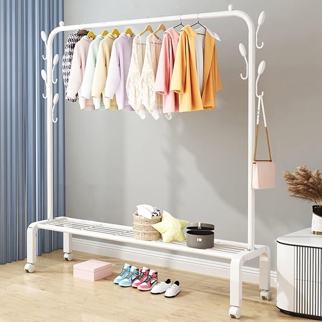 SUSUZI Support à Vêtements à Tige Simple de 51 Po en Blanc, Conçu comme un Organisateur de Garde-Robe Robuste avec une Tige de 51 Po pour Suspendre des Vêtements, 6 Crochets Latéraux pour Accessoires et une Tablette Inférieure de 8 Po pour Chaussures Ou Bacs de Rangement. le Support Comprend 4 Roues Pivotantes Verrouillables pour une Mobilité Facile et des Extrémités de Tige Antidérapantes pour Empêcher les Cintres de Glisser. Idéal pour le Rangement de Vêtements dans les Chambres, Garde-Robes Ou Entrées, Montré dans une Pièce Moderne avec des Vêtements, des Chaussures et des