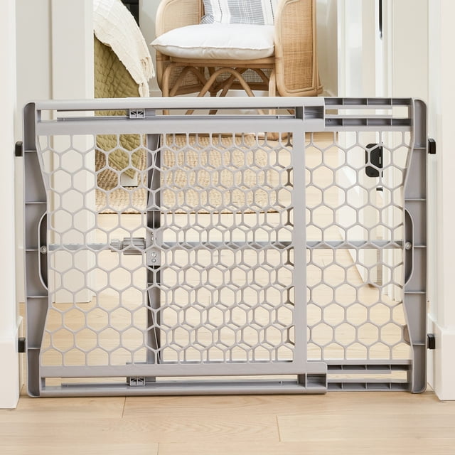 Regalo Plastic Gate centered front-facing view of an easy-fit plastic baby safety gate with top latch; expandable panels fit stairways and openings 28 to 42 inches wide and the gate stands 23 inches tall, shown installed in an opening.