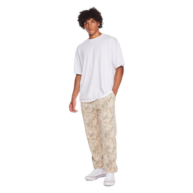 No Boundaries All Gender Cotton Short Sleeve Oversize Tee in white featuring a relaxed oversized fit, crew neckline, and drop shoulder sleeves, styled with beige patterned pants and white high-top sneakers in a casual standing pose on a white background.