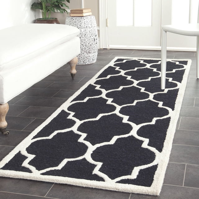 Safavieh Cambridge Kevin Tapis Géométrique pour Aire avec Motif Géométrique Noir et Blanc et texture de Laine Tuftée à la Main, Posé sur un Plancher de Carreaux Foncés dans une Pièce Lumineuse avec un Meuble d'Accent Blanc et un Tabouret Décoratif en Céramique, Souvent Utilisé comme Tapis d'Accent pour la Maison Ou le Bureau.