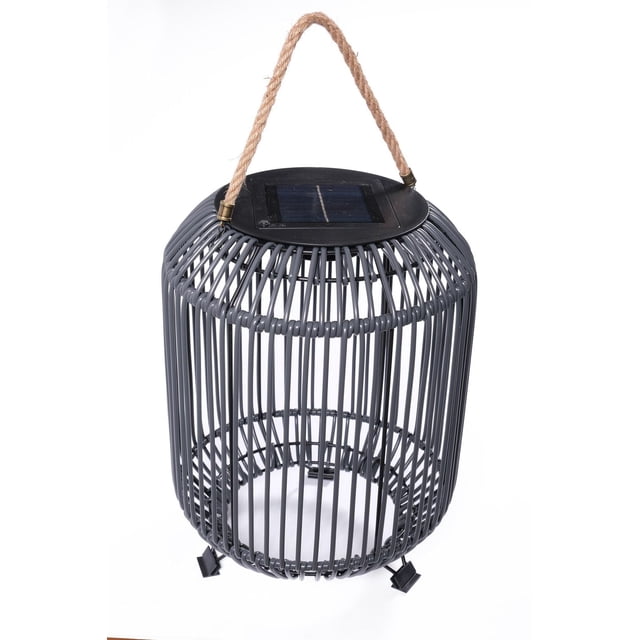 Dura Osier Synt Solar Lantern avec un Cadre Moderne Cylindrique en Osier Synthétique Gris Foncé avec Lattes Verticales, un Panneau Solaire Noir sur le Dessus et une Poignée en Corde Naturelle, Conçu pour les patios et Balcons Extérieurs, Posé sur Trois Petits Pieds Noirs.