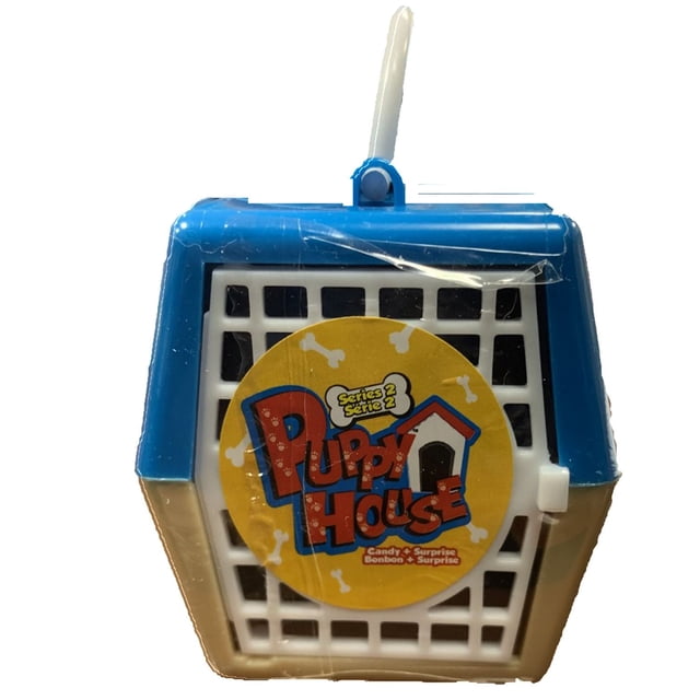 Exclusive Brands Puppy House Series 2 Candy + Surprise plastic crate toy in blue and beige with a white handle and front grid door featuring a yellow circular label with Puppy House Series 2 text and bone graphics, containing collectible toy puppies and bone-shaped hard candies in a resealable container.