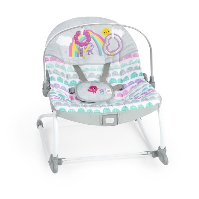 Bright Starts Rosy Rainbow Infant to Toddler Rocker with white metal frame and padded seat featuring pastel rainbow and bird patterns, toy bar with heart-shaped rattle and flower bead chaser, one-button vibration, adjustable recline, and front kickstand to switch between rocker and stationary seat for babies up to 40 lbs.