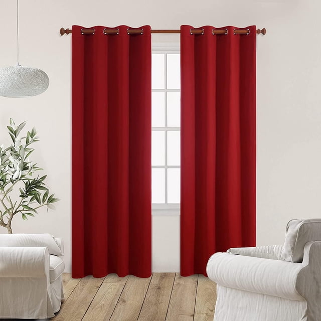 Panneau de Rideau à Oeillets Bloqueur de Soleil Isolé Thermiquement 100 % Occultant dans une Teinte Rouge, Suspendu sur une Tringle en Bois avec Oeillets Métalliques dans une Pièce Lumineuse avec Murs Blancs, Plancher de Bois Clair, un Fauteuil Blanc et une Plante en Pot Verte, Idéal pour l'Isolation Thermique et la Réduction du Bruit.