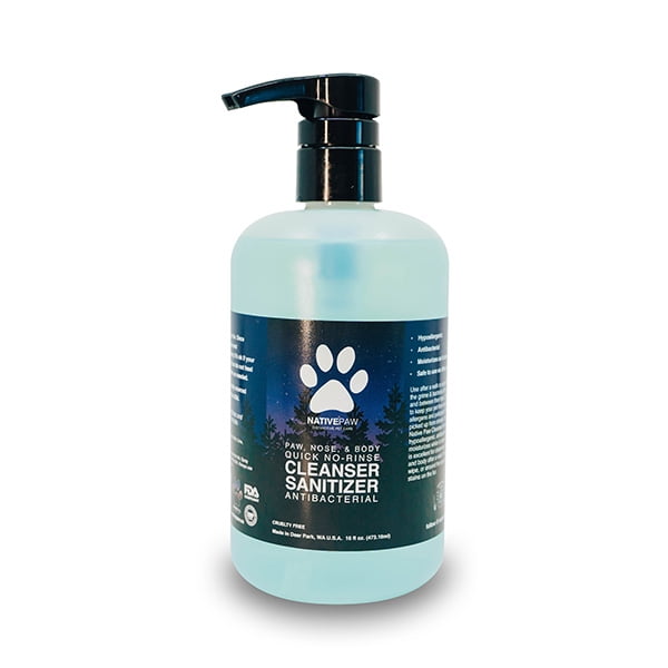 Nettoyant Antibactérien Sans Rinçage pour Pattes, Nez et Corps Autochtones, Bouteille de 16 oz Blanche Centrée Orientée vers l'Avant avec Bouchon à Rabat et Étiquette Montrant le Nom de la Patte Autochtone et le Titre du Produit; Conçu pour Essuyer les Pattes, le Nez et le Corps pour Nettoyer la Saleté, la Crasse et les Bactéries Tout en Hydratants; Sûr à Utiliser Autour du Nez, des Yeux et des Oreilles; Fond Blanc Uni; Utilisé Souvent sur les Pattes d'Animaux Domestiques et de Ferme après une Activité Extérieure.