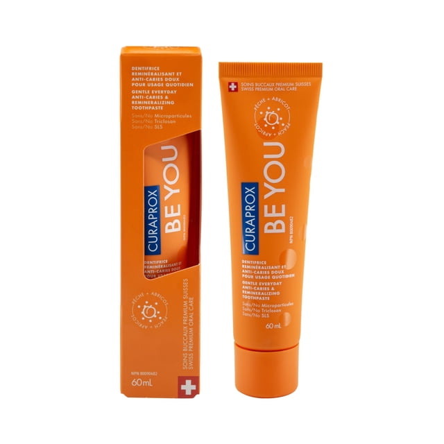 Curaprox Be You Peach and Apricot - Teeth Whitening Toothpaste in a 60ml tube, displayed with its orange box. This low fluoride toothpaste gently whitens teeth using natural enzymes, protects against cavities with fluoride and xylitol, and strengthens enamel with hydroxyapatite. The peach and apricot flavor adds a refreshing touch, making it ideal for daily oral care.