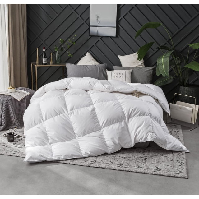Royal Elite Couette en Duvet de Canard Huttérite avec design de Boîte à Cloisons Matelassée Blanche et Enveloppe en Coton 400 Fils, Remplie de Duvet de Canard Huttérite 675 de Pouvoir de Remplissage. Cette Couette Hypoallergénique, Toutes Saisons, Est Conçue sur un Lit avec des Oreillers Gris et Blancs, un Mur à Texture Foncée et un Décor Moderne Incluant des Plantes Vertes.