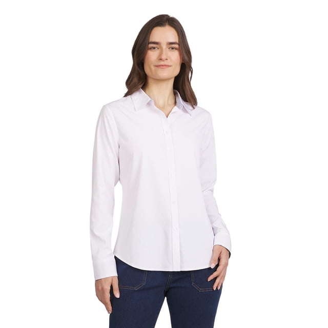CHAPS CLASSIC SHIRT is a white women's tailored button-down shirt with long sleeves and a pointed collar, shown tucked into dark blue denim jeans. This versatile blouse suits office or casual wear and is often used as a layering piece.