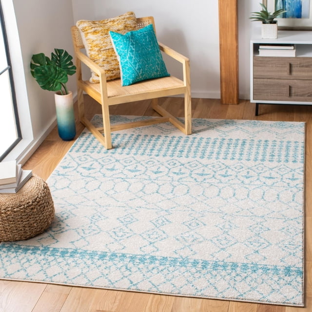 Safavieh Tapis Géométrique Marocain Tulum Coriandre avec Laine Pelucheuse et Motifs Géométriques Bleus sur Fond beige, Placé sous une Chaise en Bois Clair avec Siège et Coussins Tissés, à Côté d'Un pouf Tissé et d'Une Plante Décorative, Convient pour Ajouter de la Chaleur au décor Contemporain de la Maison.