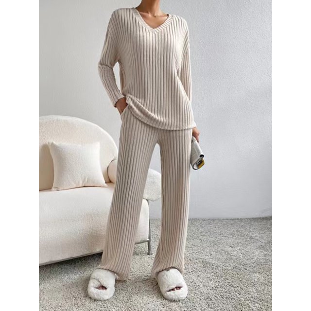 Womens Two Piece Lounge Sets Long Sleeve Knit Pullover Tops Wide Leg Pants Fall Pajamas Sets. This beige ribbed knit loungewear set includes a V-neck long sleeve top and wide-leg pants, offering a relaxed fit ideal for casual wear, lounging, or fall and winter occasions. Perfect for women's loungewear or as a fall sweater set. Displayed in a cozy indoor setting with a neutral-toned background.