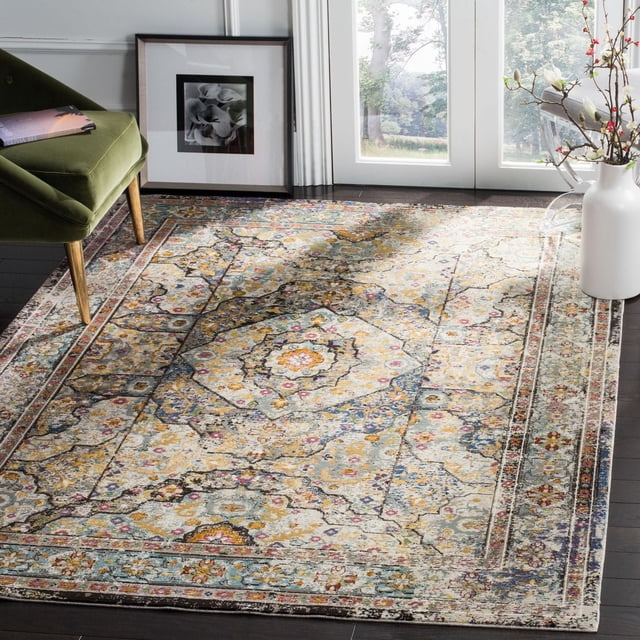 Safavieh Aria Lucy Tapis Traditionnel 8 par 10 Pieds avec un design Usé d'Inspiration Persane Présentant des motifs Floraux et des Médaillons en beige, Bleu, Jaune et Rose. construction en Fil Synthétique Tissé Mécaniquement Offre une Durabilité pour les Zones à Fort Passage. Exposé sur des Planchers de Bois Franc Sombres Près d'Une Chaise en Velours Verte, photo Florale Encadrée et vase Blanc avec des branches en Floraison, Convient aux accents Contemporains pour la Maison.