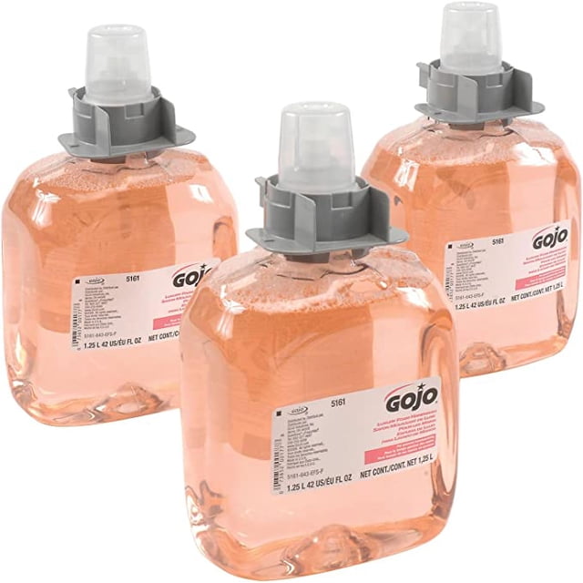 Gojo 5161-03 FMX-12 Foam Soap refills, displayed as three transparent containers filled with orange foaming soap. Each refill includes a grey push dispenser cap and a viewing window for easy maintenance. Designed for use in GOJO FMX-12 Dispensers, these refills provide a rich, creamy lather infused with air for gentle handwashing. Enriched with vitamins and moisturizers, the soap offers a fresh, clean scent, ideal for hand care and personal hygiene.