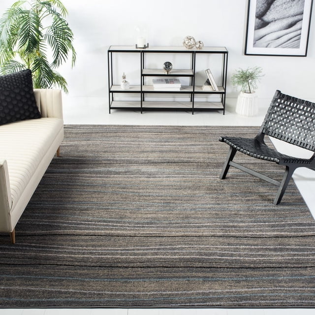 SAFAVIEH Amsterdam Aragon Striped Area Rug in a modern living room, featuring a durable low-pile rug with horizontal stripes in rustic earth tones of brown, gray, and subtle blue. It is placed on a white floor between a cream sofa with a black textured pillow and a black woven accent chair, near a black metal and wood shelving unit with decorative items and a green potted plant. The rug is suitable for adding rustic-chic style and comfort to accent spaces.