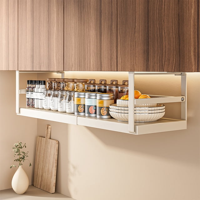 EGNMCR pantry organization basket with adjustable telescopic design, crafted from durable white steel. Installed under a wooden cabinet, it holds spice jars, tins, and bowls, ideal for maximizing storage space in kitchens, bathrooms, or pantries.