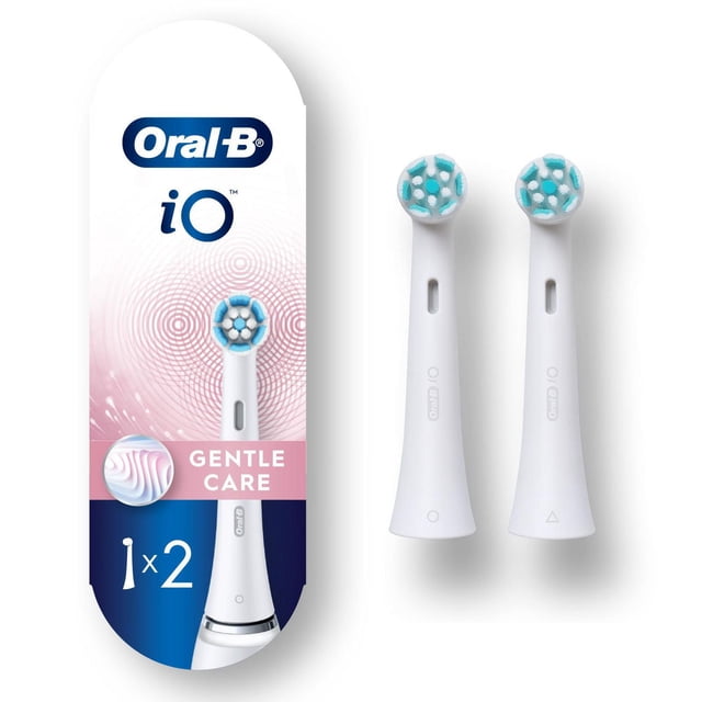 Oral-B iO Gentle Care Replacement Heads, two white electric toothbrush brush heads with high density extra soft bristles arranged in a circular pattern, shown next to packaging featuring the Oral-B iO logo and gentle care label, designed for a gentle clean and compatible with Oral-B iO electric toothbrush handles.