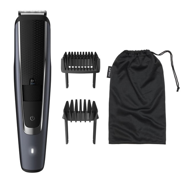 Philips Beardtrimmer Series 5000 with matte dark gray and black body, textured grip, power button, and LED battery indicator, including two black adjustable comb attachments and a black drawstring pouch, designed for precise beard trimming with 40 lock-in length settings.