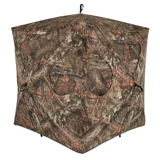 Ameristep Silent Brickhouse™ Ground Blind in camouflage Durashell™ Plus fabric with a hexagonal shape, featuring a silent hinged door, shoot-through mesh windows with gun ports, brush loops for natural foliage, and a rugged Spider Hub® frame for quiet, easy setup and takedown.