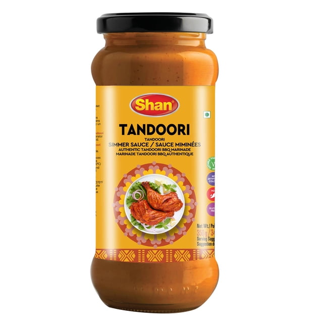 Shan Tandoori Cooking Sauce 12.3oz (350g) in a clear glass jar with black lid, featuring a yellow label with the Shan logo and an image of grilled tandoori chicken on a white plate with onions and greens, perfect for marinating and simmering meats, seafood, or vegetables to create authentic smoky and spicy tandoori dishes at home.