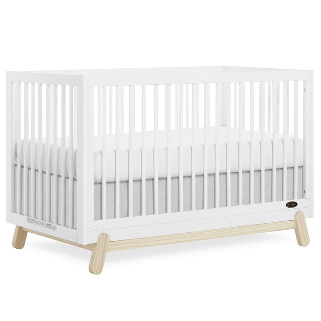 Dream On Me Hygge Lit de Bébé Convertible 5-en-1 en Chêne Blanc vintage avec Cadre Rectangulaire, Lattes Verticales et Pattes Naturelles de Style Scandinave, Conçu pour Se Convertir du Lit de Bébé au Lit pour Tout-Petit et Lit Double, Montré avec Matelas Blanc et Drap-Housse Gris Pâle.