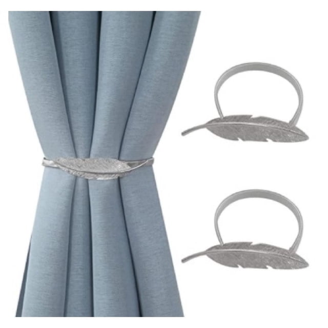 IH Casa Decor Set Of 2 Curtain Tiebacks Feather Silver holding back light blue curtains, featuring silver metallic feather-shaped tiebacks with detailed vein texture, ideal for drapery hardware and window coverings, also suitable for decorative home accents.