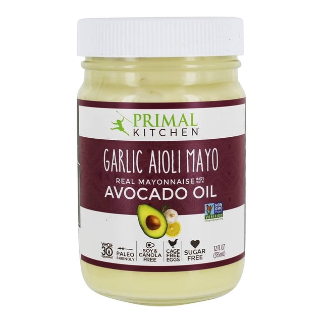Primal Kitchen Vraie Mayo Faite avec de l'Huile d'Avocat Aïoli à l'Ail dans un Pot de 12 fl oz (355 ml). la mayonnaise Crémeuse Est Exposée dans un Pot Transparent avec un Couvercle Blanc, Présentant une Étiquette Qui Met en Valeur Sa Saveur d'Aïoli à l'Ail et la base d'Huile d'Avocat. l'Étiquette Comprend Également des Icônes pour Être Compatible Paléo, Sans Soya Ni canola, Oeufs Sans Cage et Sans Sucre, Ainsi Qu'une certification Vérif