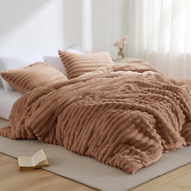 Regency Heights Full/Queen Size Comforter Set, a fluffy ribbed plush bedding set in brown. Perfect for kids' bedding, it includes a 90-inch by 90-inch comforter and two 20-inch by 26-inch shams with overlapping enclosures. Crafted with premium 300 gsm fabric for extra weight, softness, and warmth, and Oeko-Tex certified for safety and skin gentleness. The comforter features an ultra-soft mink reverse and invisible tacking for a seamless look. Displayed on a bed in a bright, minimalist room with natural light.