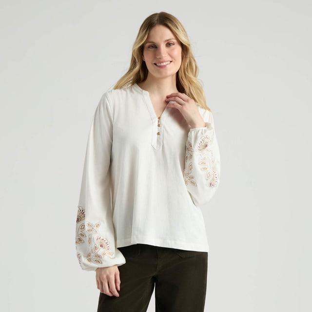 Mexx Blouse à Manches Bouffantes à Col Mao pour Femmes en Blanc Cassé 100 % Coton avec Longues Manches Bouffantes Présentant des Détails Floraux Bruns et Beiges Appliqués Près des Poignets Élastiques, un Col Mao Boutonné et une Coupe Décontractée, Style avec Pantalon Foncé sur un Fond Uni.