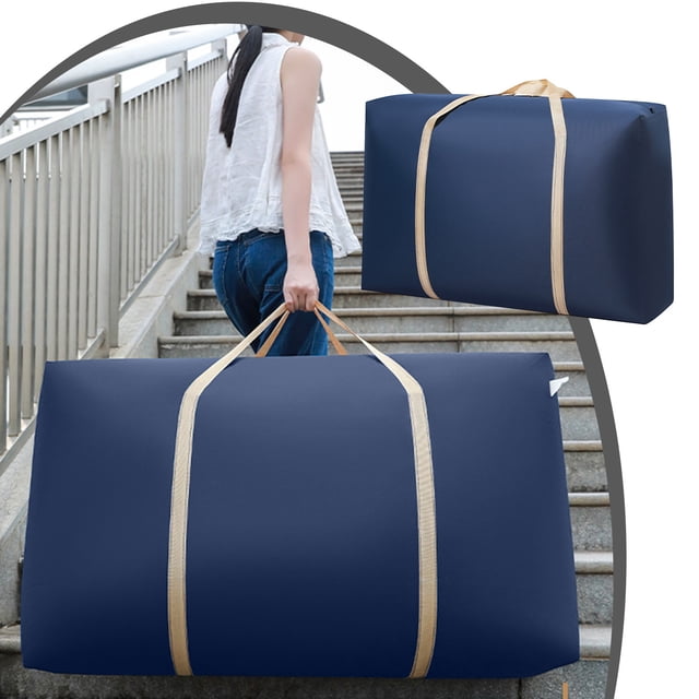 TIMIFIS Extra Large Storage Bag in navy color, featuring strong zippers and beige carrying handles. This oversized storage bag is ideal for organizing clothes, blankets, quilts, pillows, and holiday items like Christmas decorations. Made from durable non-woven fabric, it measures approximately 70×50×25cm and is lightweight at 202g. Suitable for closet organization, travel, or camping, the image shows a person carrying the bag up stairs, emphasizing its portability and spacious design.