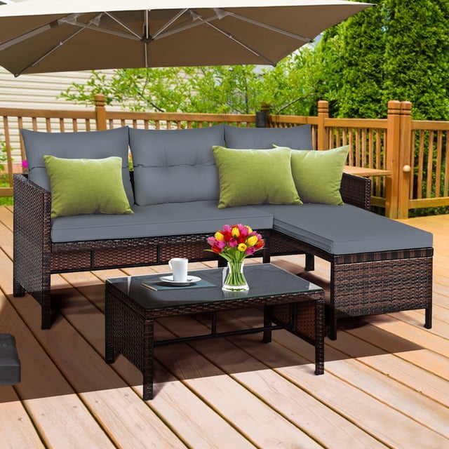 Gymax Ensemble de Meubles d'Extérieur en Rotin 3 Pcs, Ensemble de Canapé de Patio avec Coussin, Comprenant un Causeuse, une chaise Longue et une table Basse avec Dessus en Verre Trempé. l'Ensemble Est Fait d'Un Cadre en Acier durable et d'Un Rotin de Haute Qualité, avec des Coussins Gris pour le Confort. Idéal pour les patios, le Bord de la Piscine Ou les Jardins, Présenté dans un Décor de Cour Arrière avec Terrasse en Bois et Verdure.