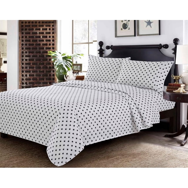 Johnson Home 200 TC Bed Sheet Set - Printed Cotton Sheets in white with black star patterns, displayed on a dark wood bed with matching pillowcases in a bright bedroom featuring coastal artwork and a side table with books and a lamp, ideal for kids' bedding and bedroom decor.