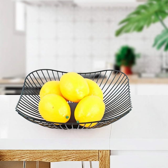 TopLLC Countertop Fruit Basket Fruit Storage Bowl Kitchen Rectangular Large Metal Fruit Snack Rack Stand, Home Decoration (square). A black, rectangular metal wire fruit basket displayed on a white countertop, holding several bright yellow lemons. The open design allows for air circulation, keeping fruits fresh. Suitable for serving fruits, vegetables, snacks, or as a decorative piece in kitchens, offices, or outdoor settings.