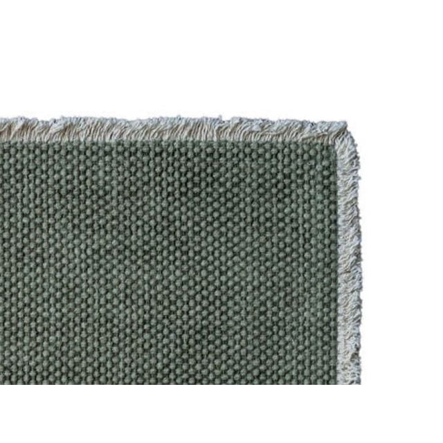 Fabstyles 100% Cotton Bali Table Runner close-up showing heavyweight woven cotton fabric in muted green with fringe trim, machine washable and suitable for dining, kitchen, and outdoor tables.