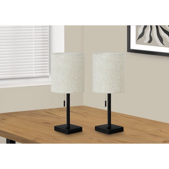 Monarch Specialties Lighting set of 2 contemporary 17-inch table lamps with black metal square bases and necks, beige fabric cylinder drum shades, pull chain switches, and USB ports on the bases, placed on a wooden table near a window with blinds and framed abstract wall art, suitable for office or bedroom use.