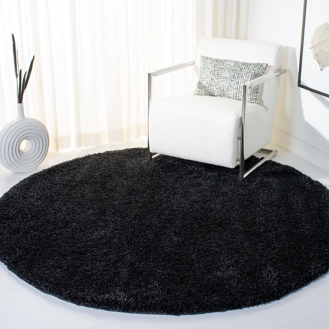 Safavieh California Tapis Shag en Peluche Uni Noir, Rond avec une pile de Polypropylène dense, Placé sous un Fauteuil Moderne Blanc avec Cadre en Métal dans une Pièce Lumineuse avec des Rideaux Transparents, Idéal pour Ajouter Douceur et Chaleur aux Espaces de Vie.