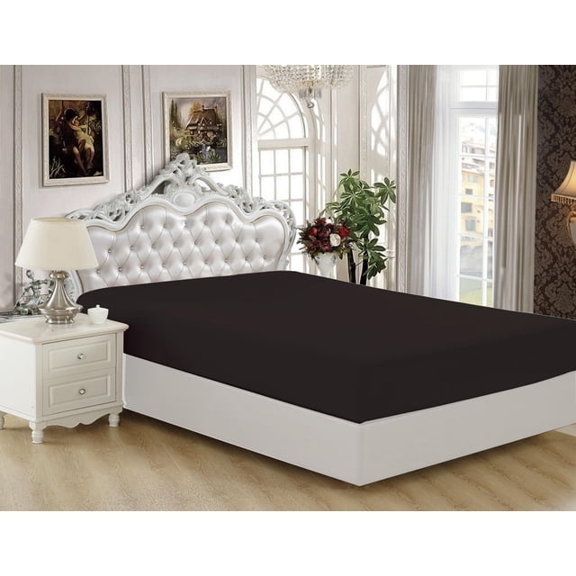 Marina Decoration Ultra Soft Silky Deep Pocket Solid Rayon from Bamboo All Season Bedding Solid Bamboo Fitted Sheet in black fitted on a white bed with an ornate tufted headboard, in a bright bedroom with a white nightstand, lamp, floral decor, and large arched windows with sheer curtains.