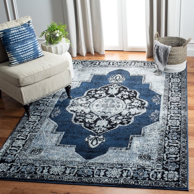 SAFAVIEH Vintage Hamadan Tahnee Tapis Traditionnel pour Pièce Lumineuse avec Planchers de Bois Franc, Présentant un Médaillon central Bleu Foncé avec des motifs Persans Noirs et Blancs et une Bordure Décorative Bleu Pâle et Gris, Placé Près d'Une Chaise beige avec un Coussin à Motif Bleu et un Panier Tressé avec un Jeté Gris, Idéal comme Tapis d'Accent Ou Centre de Table Décoratif.