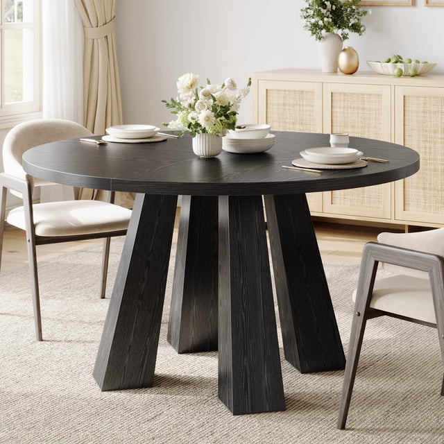 YUSAZENS 47 Inch Round Dining Table for 4 in black, designed with a sturdy base and modern minimalist style. Ideal for dining, working, or studying, this versatile kitchen table complements various interior decor. Displayed in a dining room with neutral tones, chairs, and a floral centerpiece.