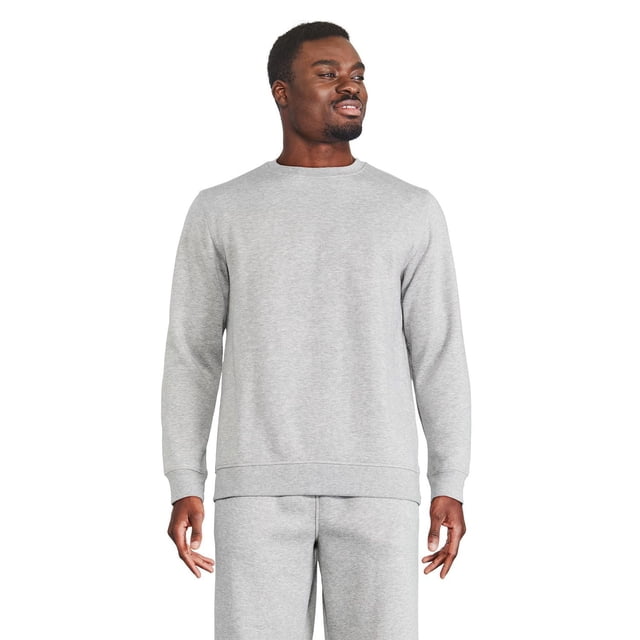 Athletic Works Men's Fleece Popover in light grey shown front-facing on a male model wearing matching fleece joggers. The crew neck pullover features long sleeves and ribbed trim at neckline, cuffs, and hem, made from a soft polyester-cotton fleece blend for warmth and casual athletic wear.