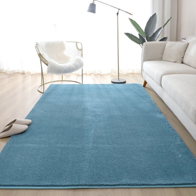 Dvkptbk Rugs for Living Room European Solid Color Carpet, shown in a soft blue tone, placed in a modern living room setting. The thickened, washable household carpet measures 60x160cm and is made from durable nylon and spandex materials. It features a slip-resistant bottom for safety and is suitable for use in living rooms, bedrooms, or offices. The rug enhances warmth and comfort while being easy to clean and maintain.