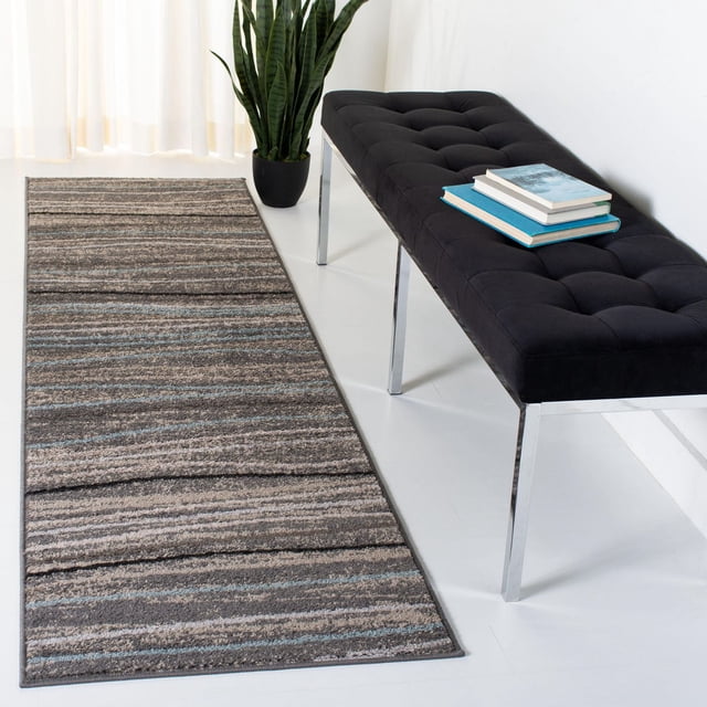 SAFAVIEH Amsterdam Aragon Striped Area Rug runner featuring rustic earth tone stripes in brown, beige, and muted blue on a white floor beside a black tufted bench with chrome legs and books, made with durable synthetic yarns and ideal as an accent rug in modern home décor with a green potted plant and sheer curtains nearby.